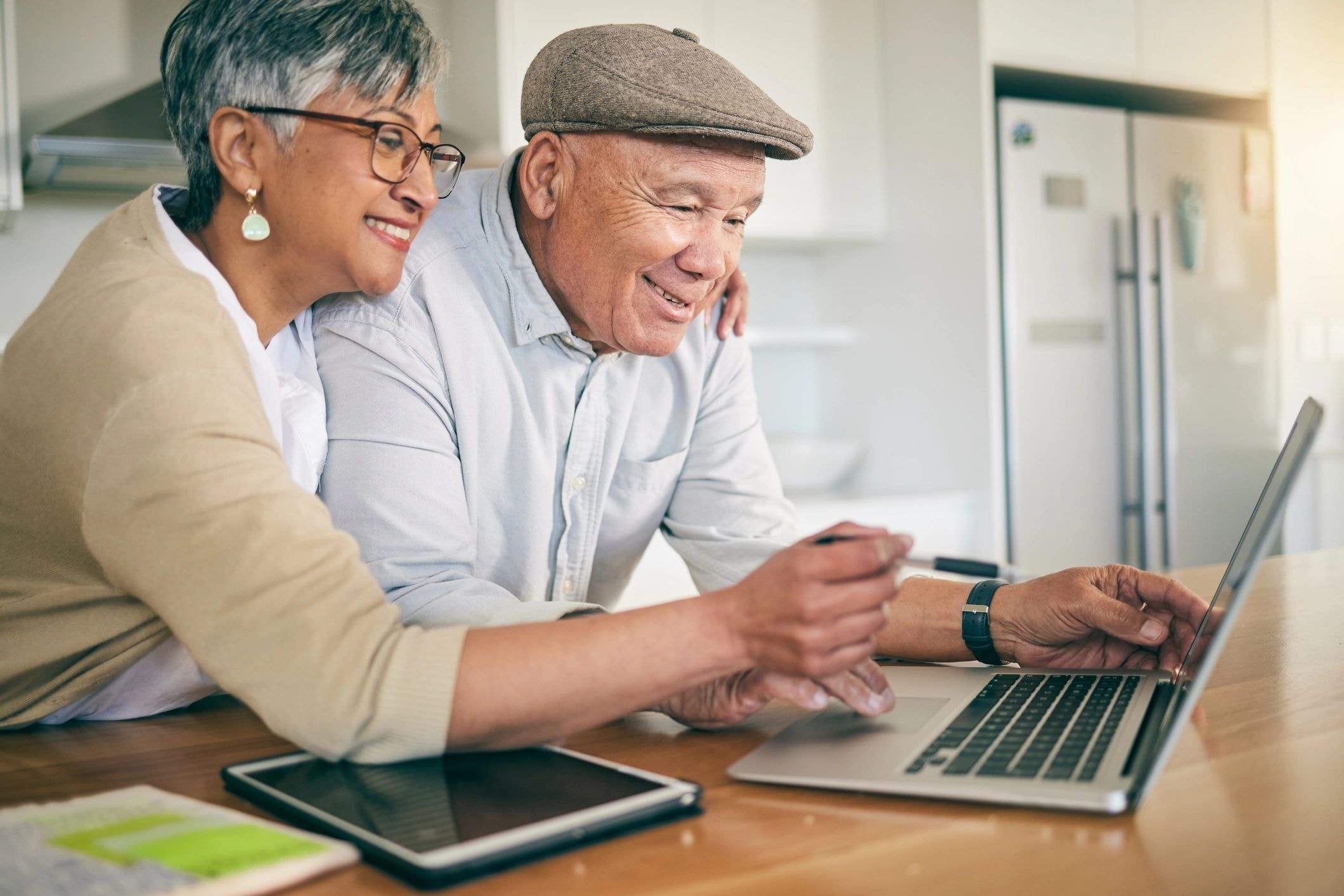 Two older adults looking at a laptop together